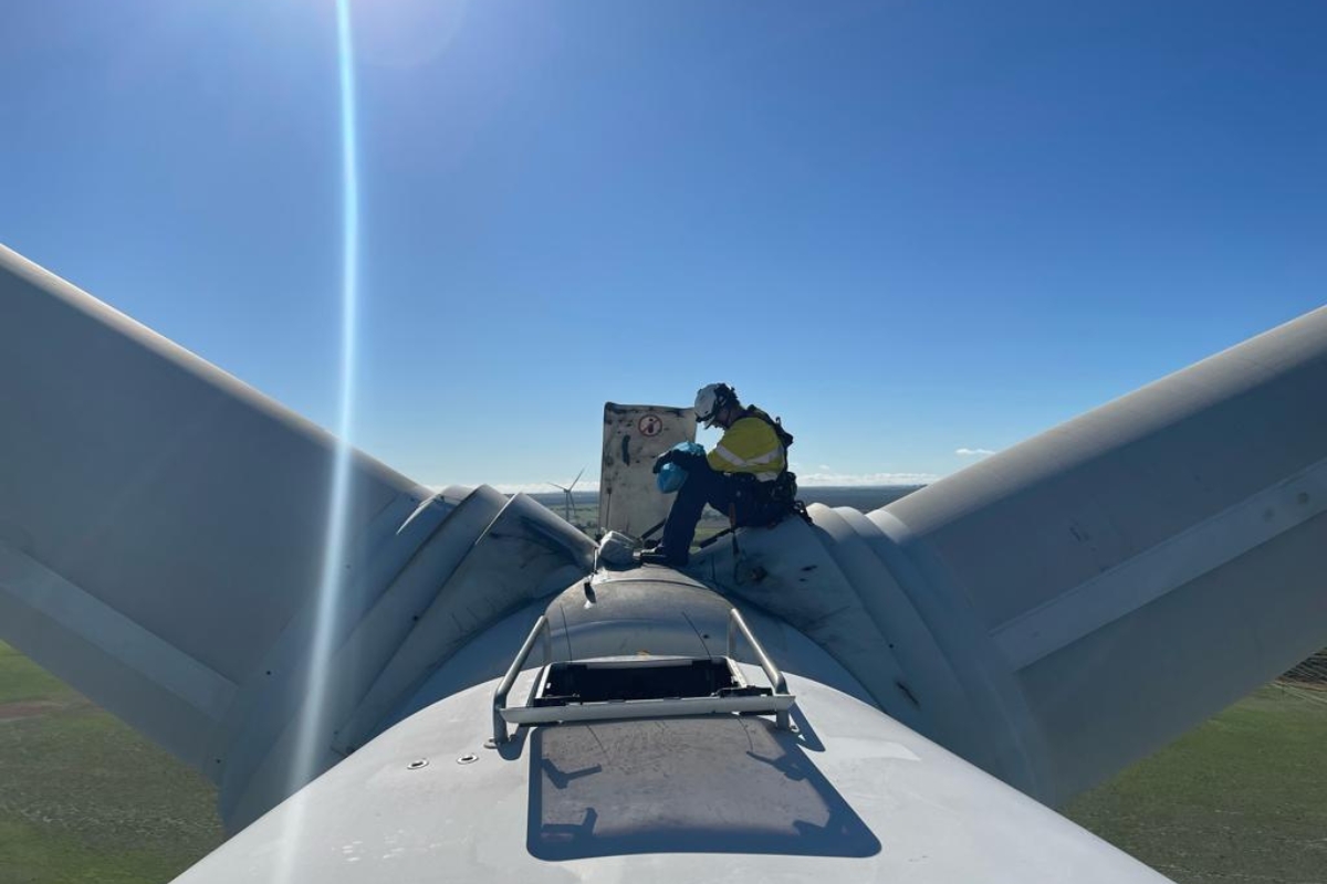 worker sitting on top of windmill